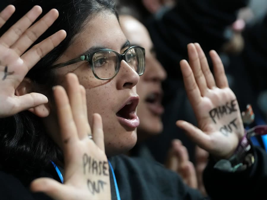 Women protesting with "Pay up!" legend on her hands