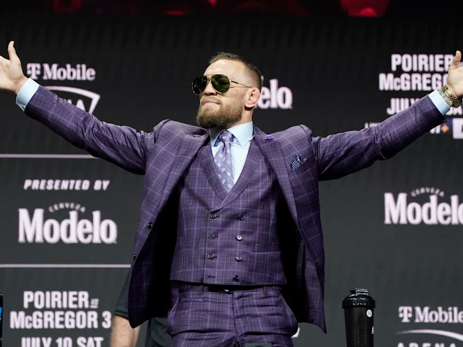 Conor McGregor raising his hands at a fight event