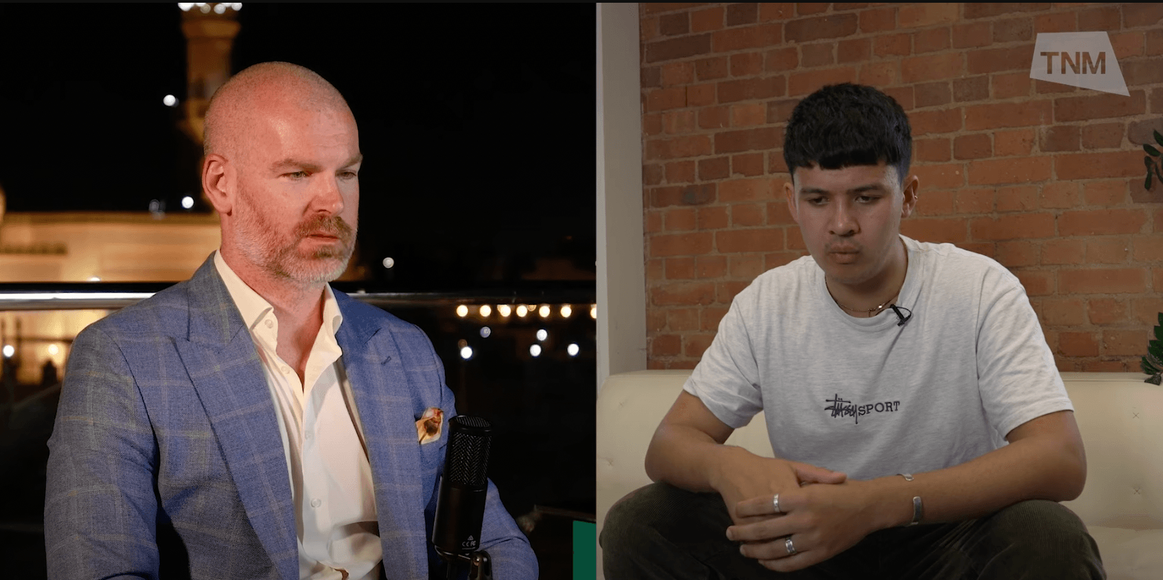 Two men talking in a split screen image. One on a white couch, the other outdoors with a white building in background. 